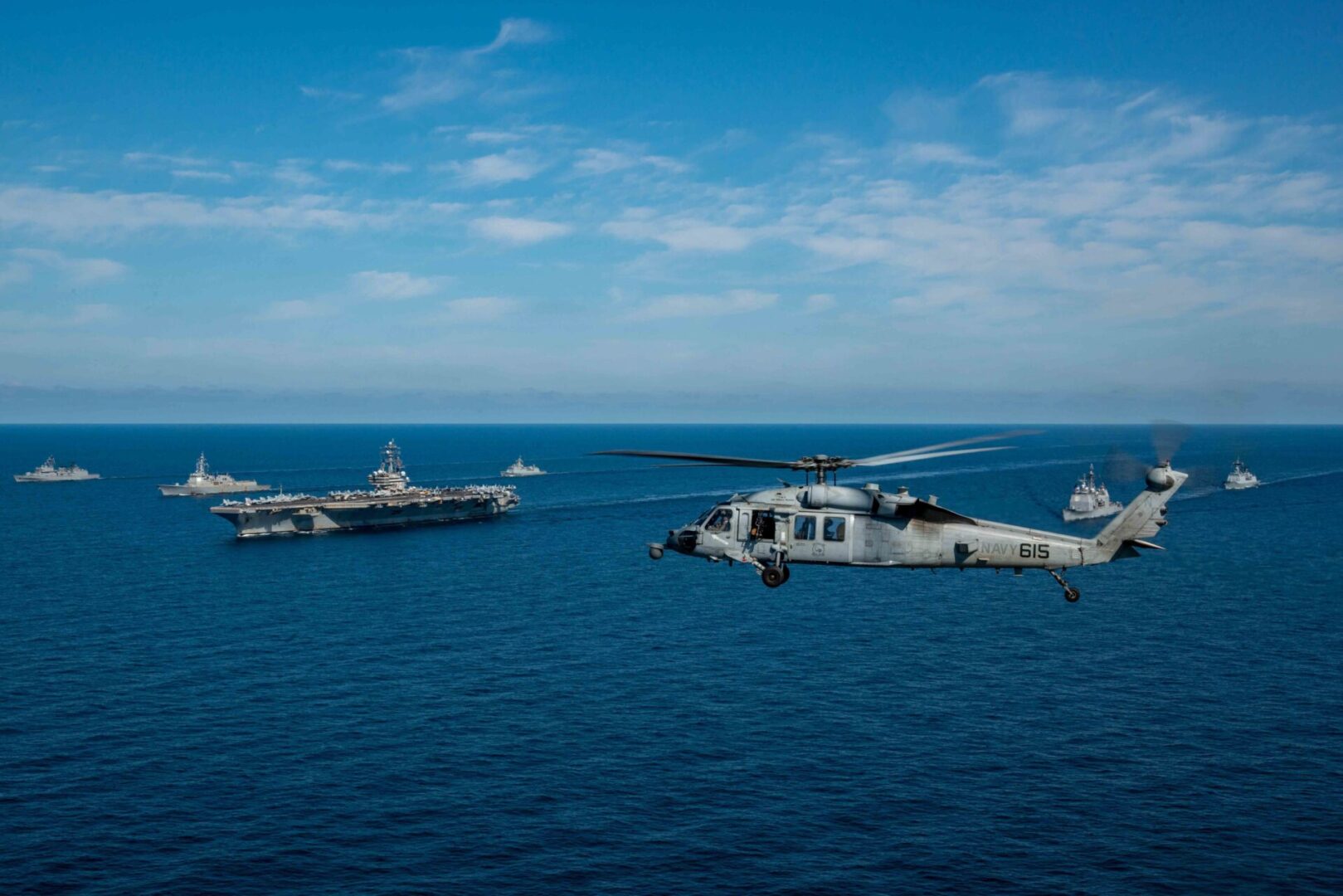 WATERS EAST OF THE KOREAN PENINSULA (Sept. 29, 2022) An MH-60S Sea Hawk helicopter attached to the Golden Falcons of Helicopter Sea Combat Squadron (HSC) 12, flies by the U.S. NavyÕs only forward-deployed aircraft carrier, USS Ronald Reagan (CVN 76), the guided0missile destroyer USS Chancellorsville (CG 62), the guided-missile destroyer USS Benfold (DDG 65) and the Republic of Korea (ROK) navy ships ROKS Gwanggaeto the Great (DDH 971), and ROKS Seoae Ryu Seong-ryong (DDG 993) steam in formation in waters east of the Korean Peninsula, Sept. 29, 2022. The Ronald Reagan Carrier Strike Group (CSG) is participating with the ROK Navy in Maritime Counter Special Operations Exercise (MCSOFEX) to strengthen interoperability and training. The U.S. routinely conducts CSG operations in the waters around the ROK to exercise maritime maneuvers, strengthen the U.S.-ROK alliance, and improve regional security. (U.S. Navy photo by Mass Communication Specialist 3rd Class Gray Gibson)
